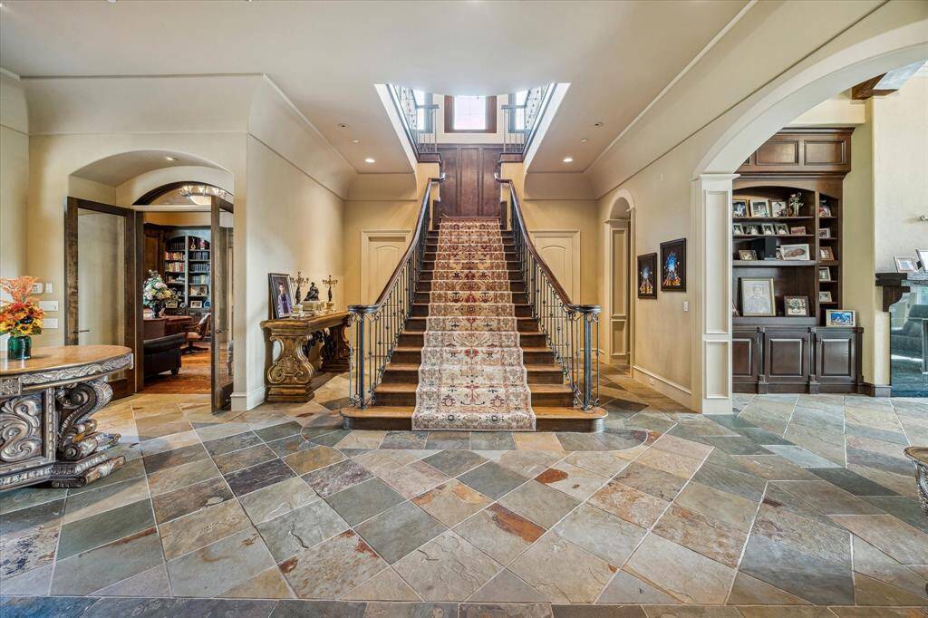 Back to the Entry, we will climb this stunning staircase with wood treads and risers; at the landing is box paneled wainscoting and a tryptic of windows.