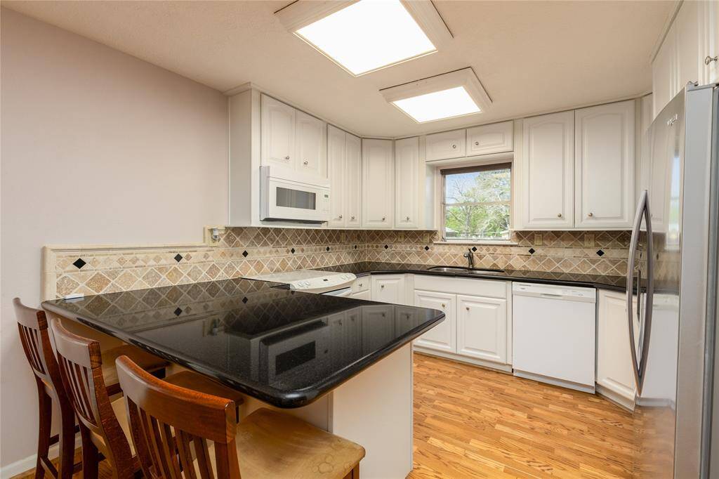 Kitchen has a Breakfast bar and granite table.