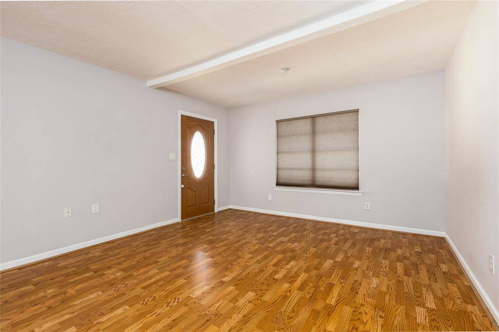 Living area has Laminate wood flooring and a large window to let in the natural sunlight into the room.
