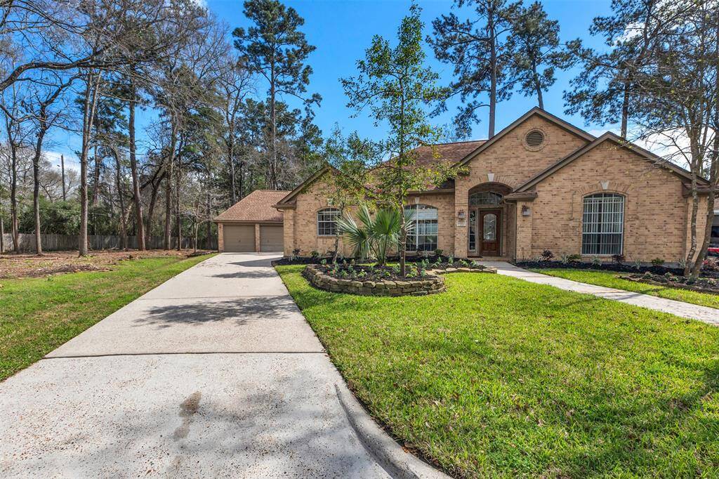 This charming brick home features a spacious front yard with mature trees and a well-maintained lawn. It offers a long driveway leading to a detached garage, and a welcoming entry with large windows for natural light. Ideal for those seeking a serene, wooded setting.