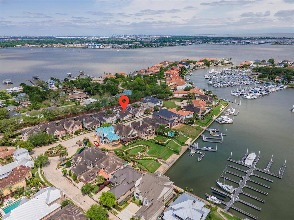 This aerial photo showcases the gated Waterford Harbor with luxurious homes and marina access. The area offers stunning water views, lush greenery, and access to a marina, ideal for boating enthusiasts.
