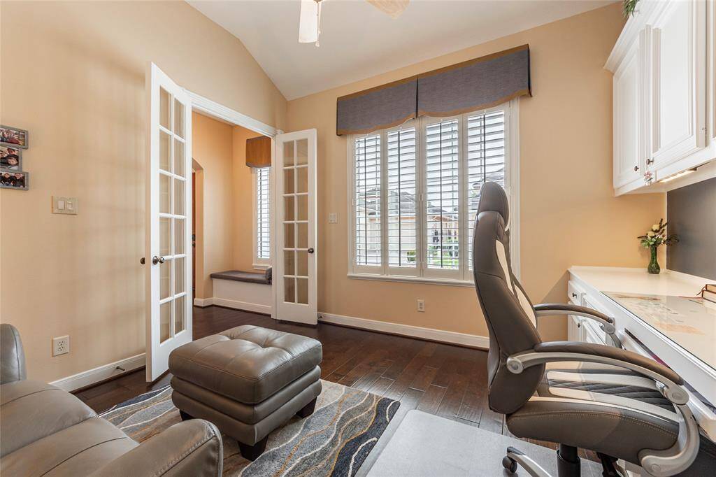 Another view of home-office with French doors and  windows with plantation shutters, displaying plenty of natural light.