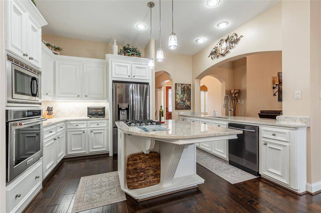 This spacious kitchen is a chef's delight with elegant white cabinetry, 3mm Quartzsite countertops, both under-cabinet & above-cabinet lighting and modern stainless steel appliances.
