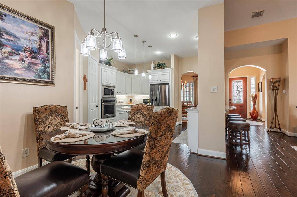 Inviting kitchen and breakfast area with elegant wood flooring and tasteful decor.  The floor plan design is both functional and stylish.