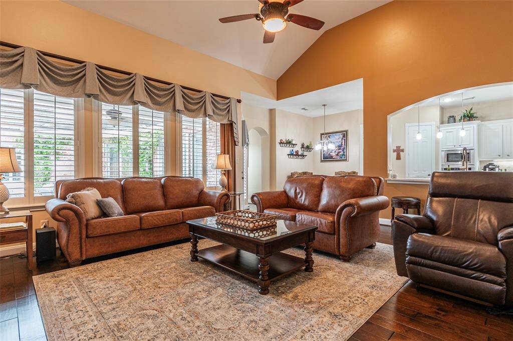 Ample natural light in the family room from large wall-of-windows.  The open layout connects seamlessly to a visible breakfast area and kitchen.