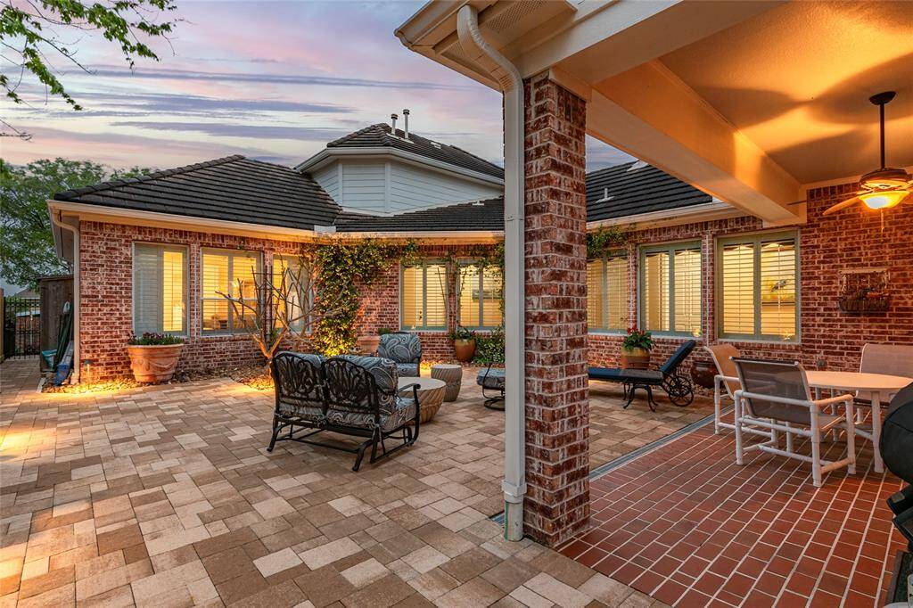 This inviting patio is an extension of living space to be enjoyed morning, noon or night. The covered area provides a ceiling fan for comfort, while large windows offer views into the home. Ideal for relaxation and gatherings.