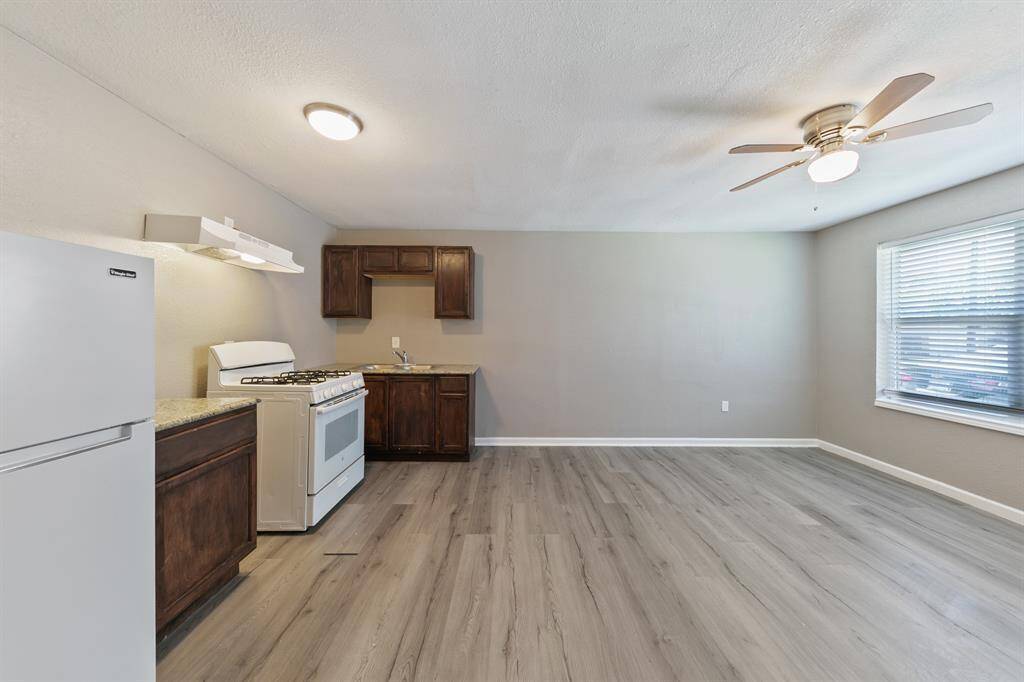 Embrace the open kitchen concept at 716 Hargest St, Prairie View! This fourplex unit features a modern kitchen with a refrigerator included, updated cabinetry, and stylish laminate hardwood floors.