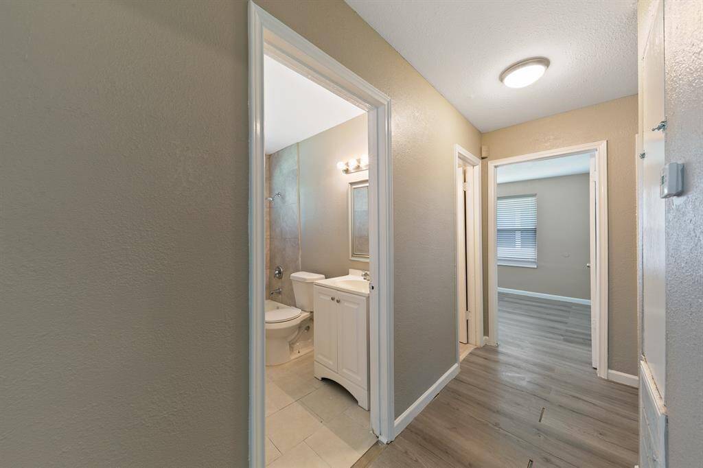 This fourplex unit features a stunning bathroom with sleek tile floors and a stylish shower backsplash.
