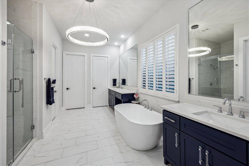 Enter into a spa like primary bath retreat with his and her vanity areas, soaking tub and seamless walk-in shower.