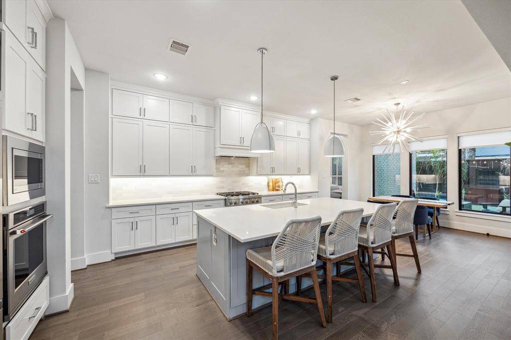 An expansive chefs kitchen with seamless quartz countertops, abundance of storage and bar seating.