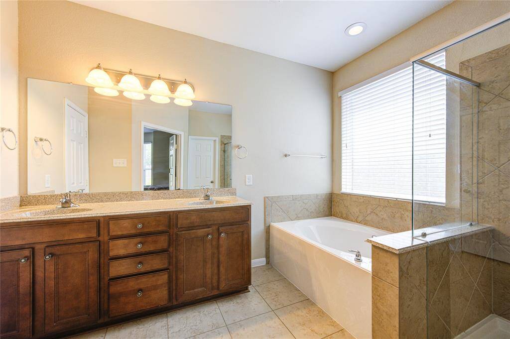 Primary bathroom has dual sinks, large shower and soaking tub.