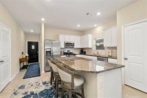Kitchen with island seating and SS appliances.
