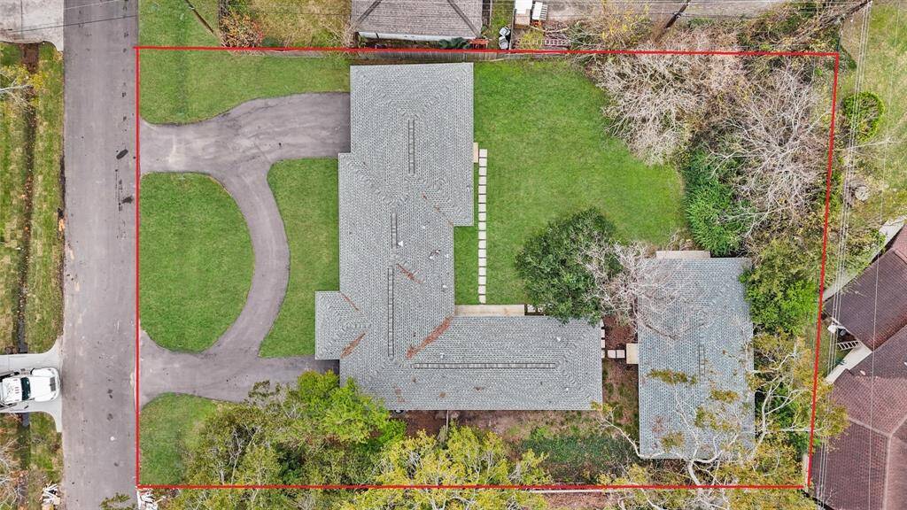 This aerial view showcases the INCREDIBLE 14,385 sqft lot with a lush lawn and mature trees.
