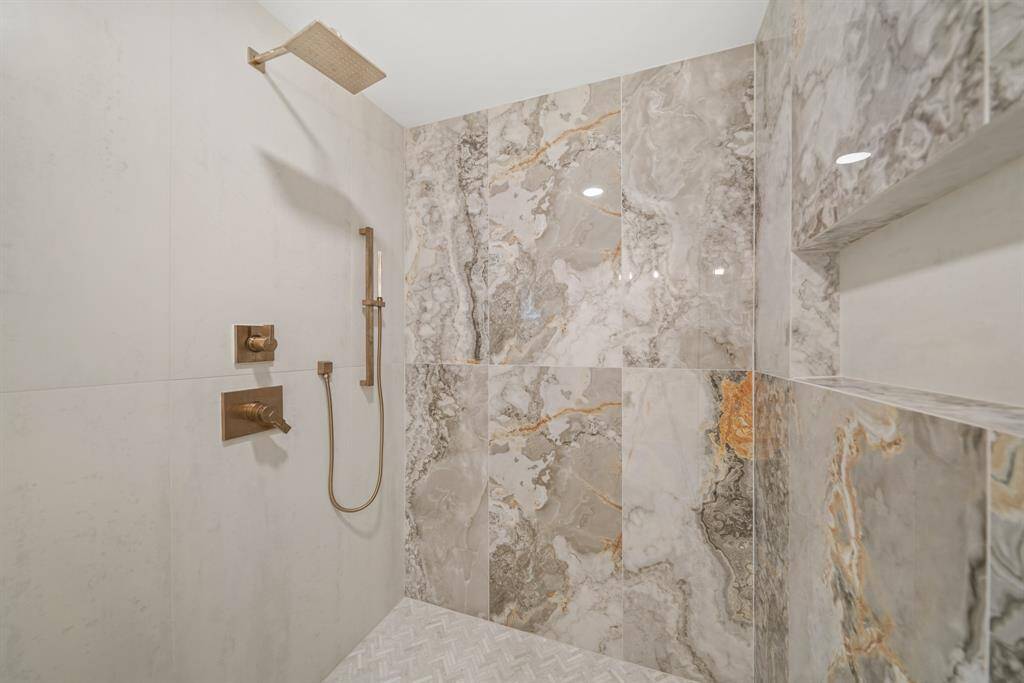 Large walk-in shower with modern tile detailing