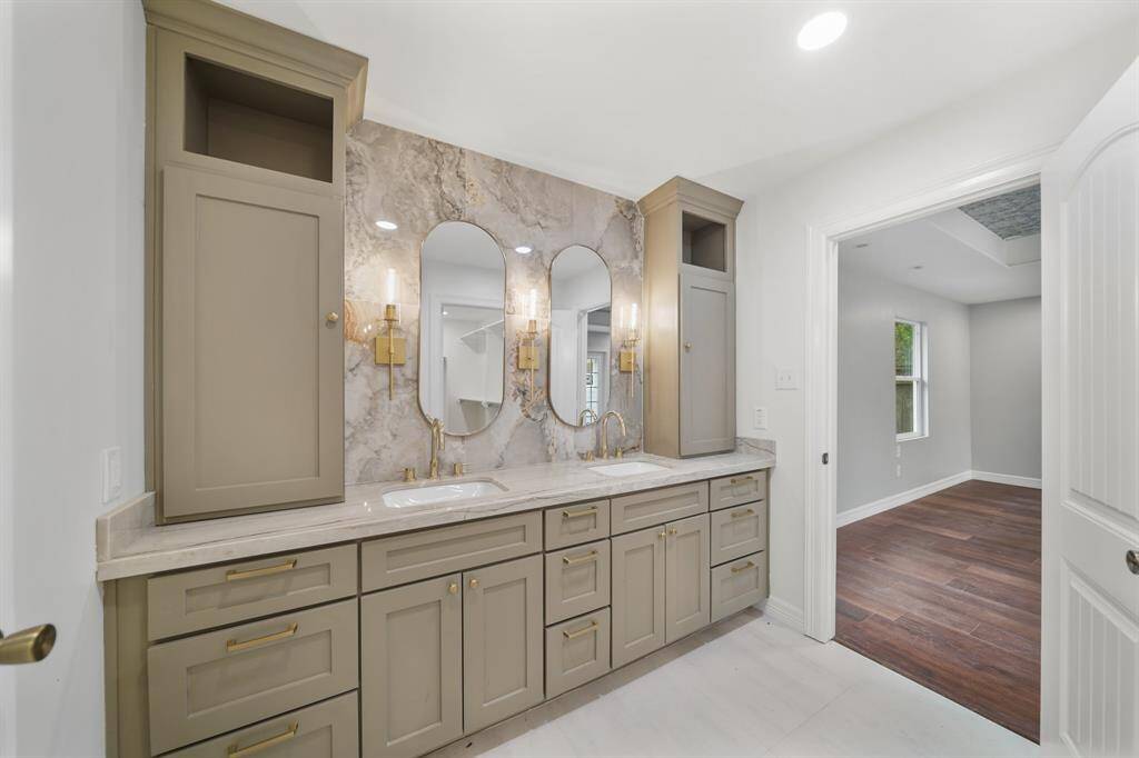 This one of a kind bathroom includes double sinks, granite countertops and luxury details, as well as plenty of storage space.