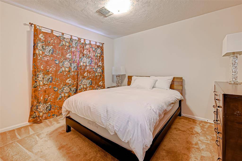 This well-sized secondary bedroom offers plush carpeting, a soft neutral palette, and a large window that invites natural light while maintaining privacy—ideal for guests, a home office, or growing households.