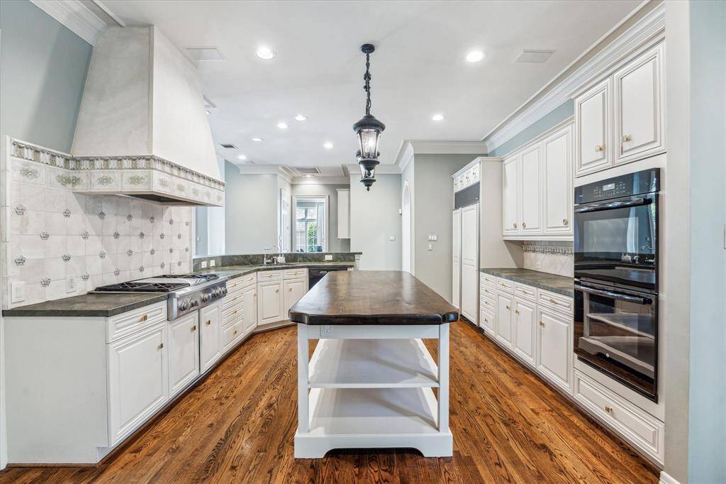 Showcasing the impressive scale and size of this kitchen, the open layout seamlessly connects to the den and dining room, creating a warm and welcoming space perfect for both cooking and entertaining.