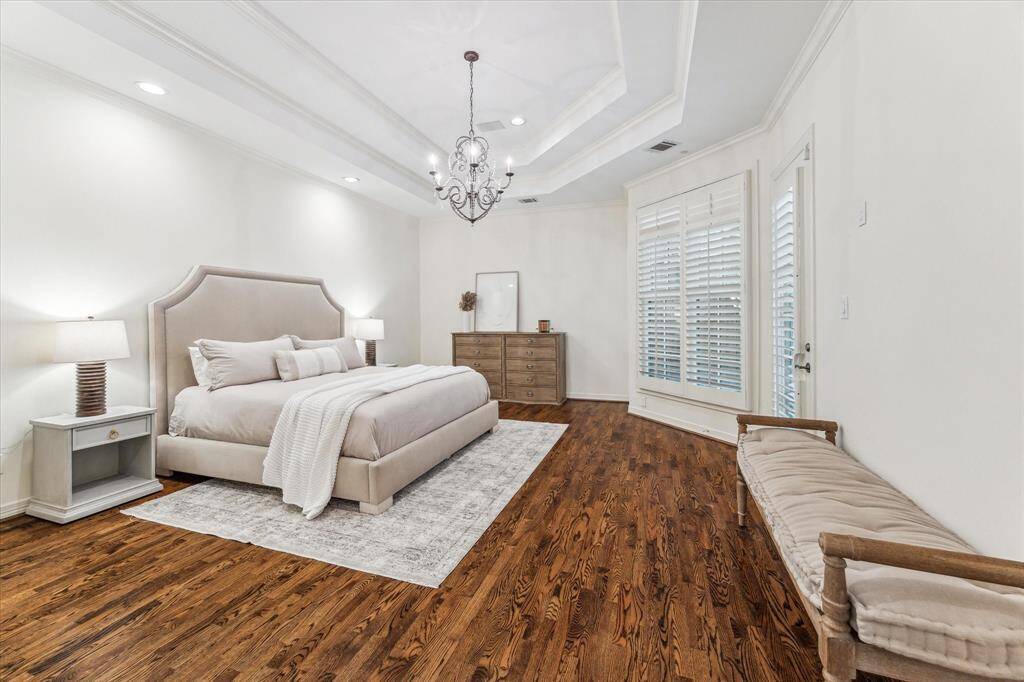 The expansive primary bedroom, located on the first floor, offers a serene view of the charming outdoor patio. Connected to a massive en suite primary bath, this space creates an incredible and inviting primary suite, perfect for relaxation and comfort.