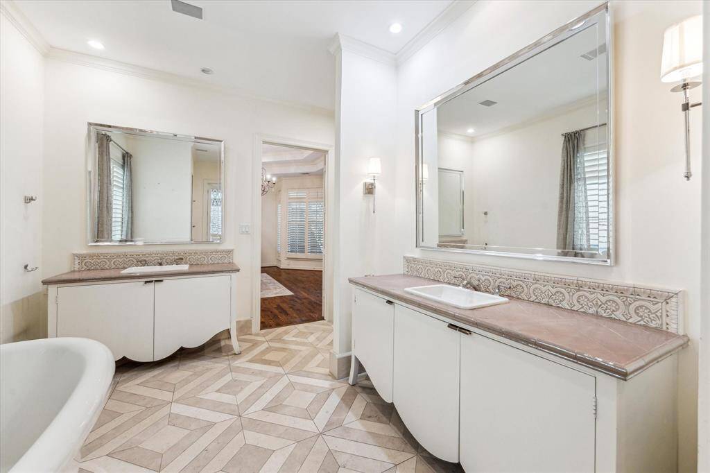 Showcasing the elegant double sinks and intricate inlaid tile, this view also highlights the seamless connection to the primary bedroom.