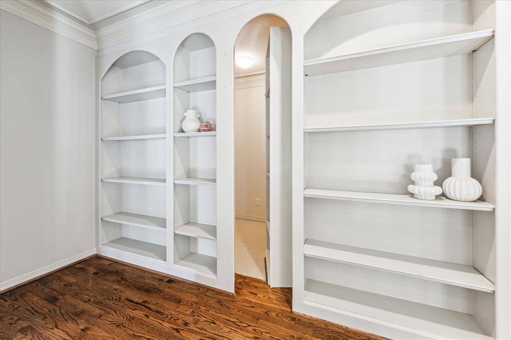 As you step onto the landing, your eyes are drawn to the elegant built-ins that line the walls. With a subtle touch, the built-in glides apart to reveal a concealed room, adding an element of mystery and surprise to the space.