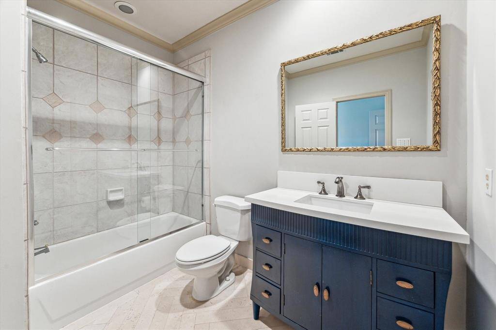 With inlaid herringbone patterned floors, this secondary en-suite bath has a nice sized walk in closet.
