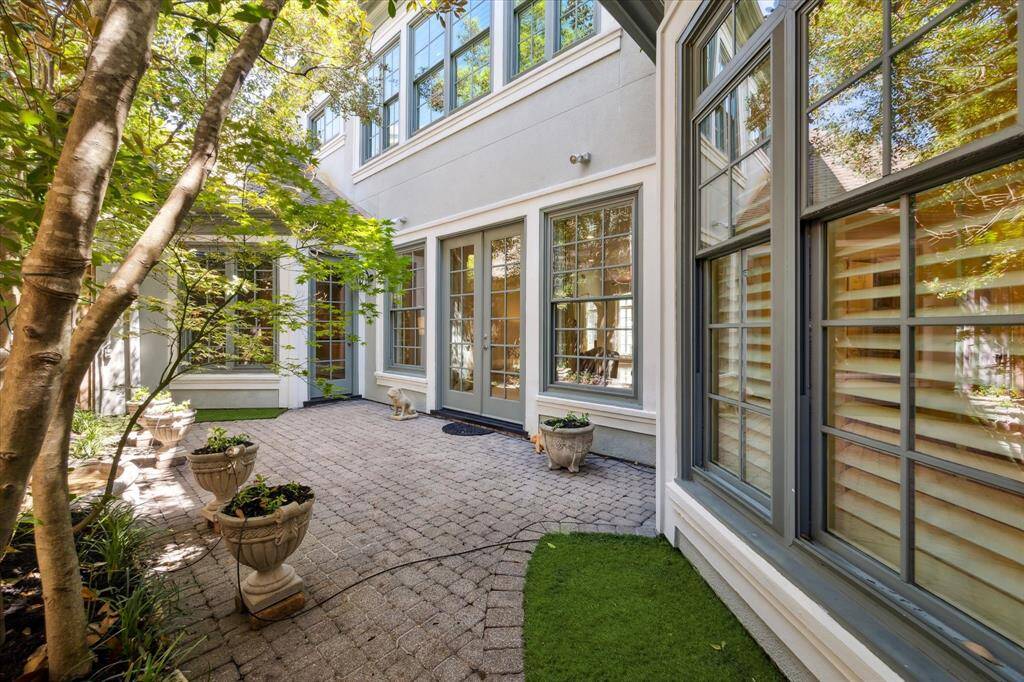 Outdoor back patio features turf, pavers, and shade.