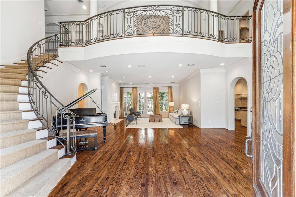 Welcome guests into your grand entryway, where soaring ceilings and exquisite balcony from the second floor create an inviting and elegant atmosphere.