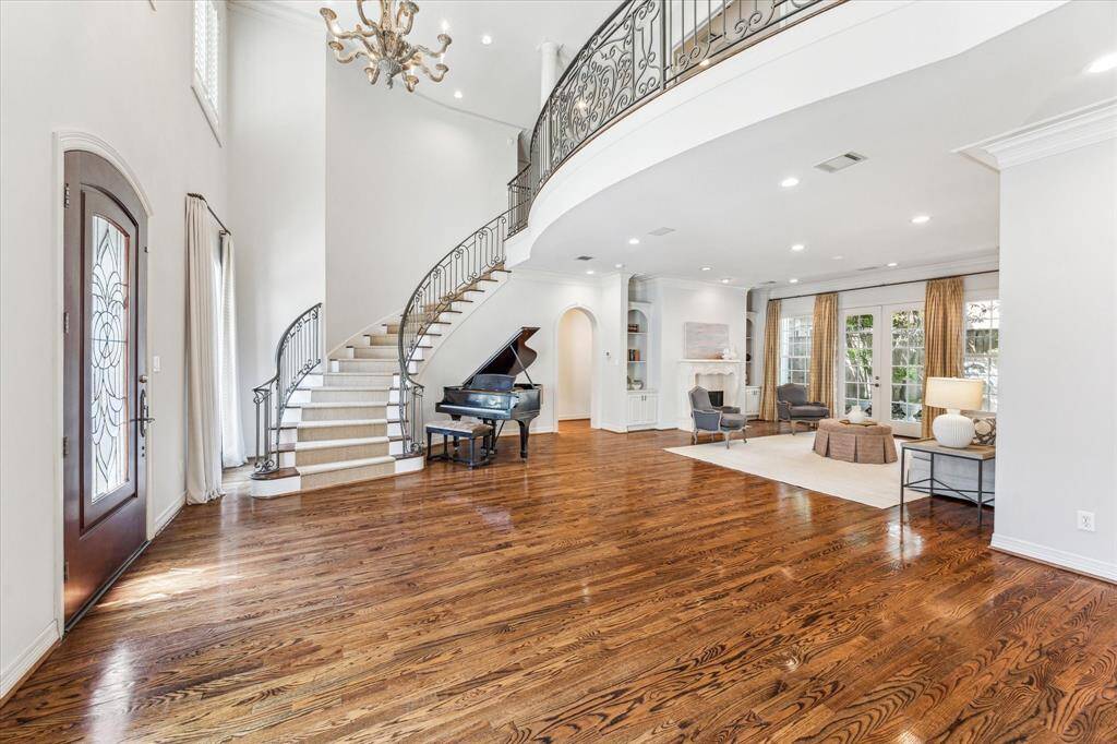 The exceptional entrance, with its spiraling staircase and open flow into the living room, creates the perfect setting for entertaining guests.