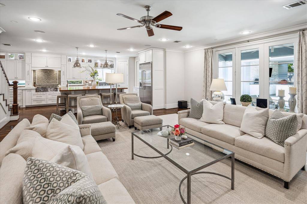 This inviting living room seamlessly connects to the kitchen and opens to the backyard patio through elegant glass doors.
