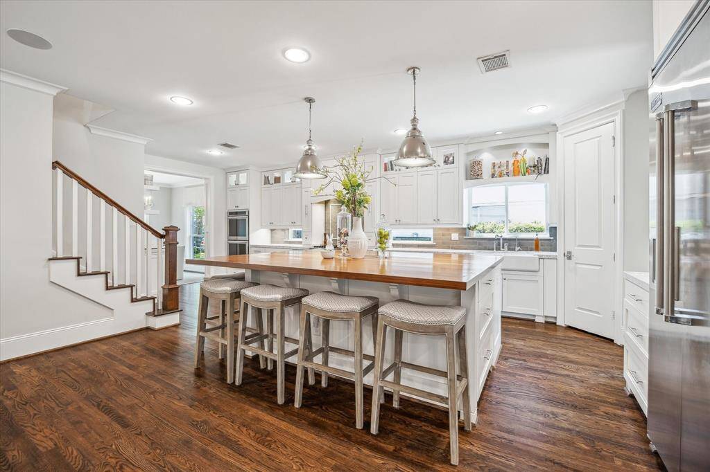 Discover this stunning kitchen with hardwood floors, ceiling-high cabinets for ample storage, and a spacious island seating six. Perfect for both entertaining and everyday living.