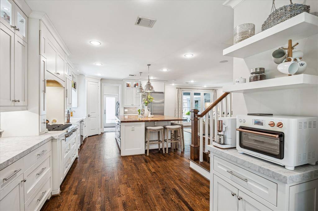 Charming coffee corner tucked away for a cozy start to your day. This angle also highlights another view of the kitchen, with a peek into the mudroom/laundry area and an additional exit to the backyard and garage. Stairs to the second floor are just to the right.