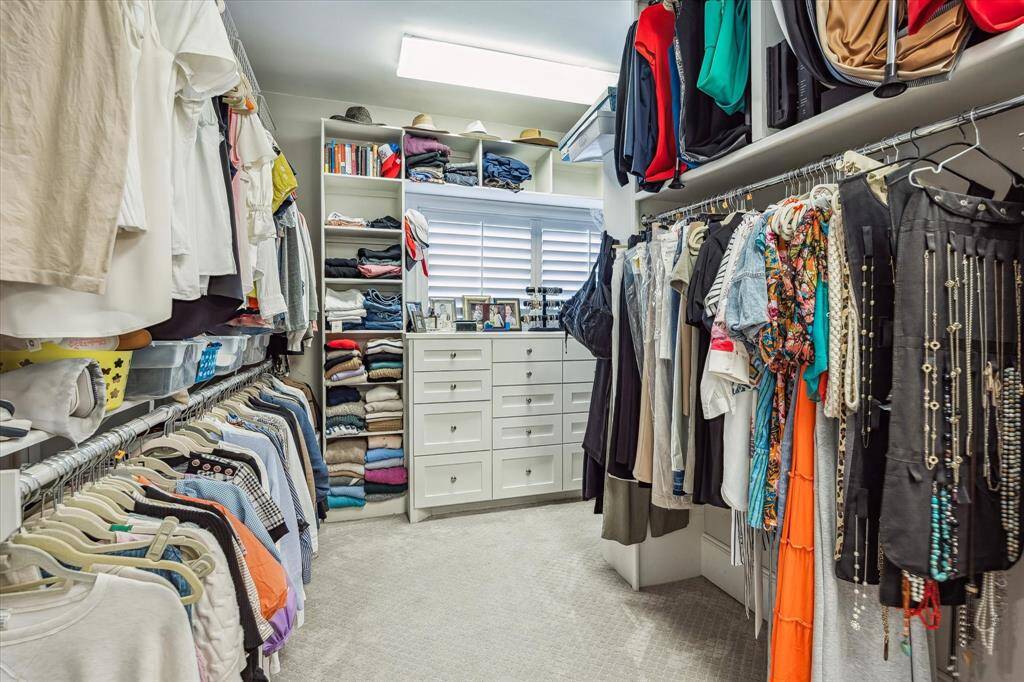 Discover the expansive wrap-around primary closet, featuring abundant built-in storage for all your needs.