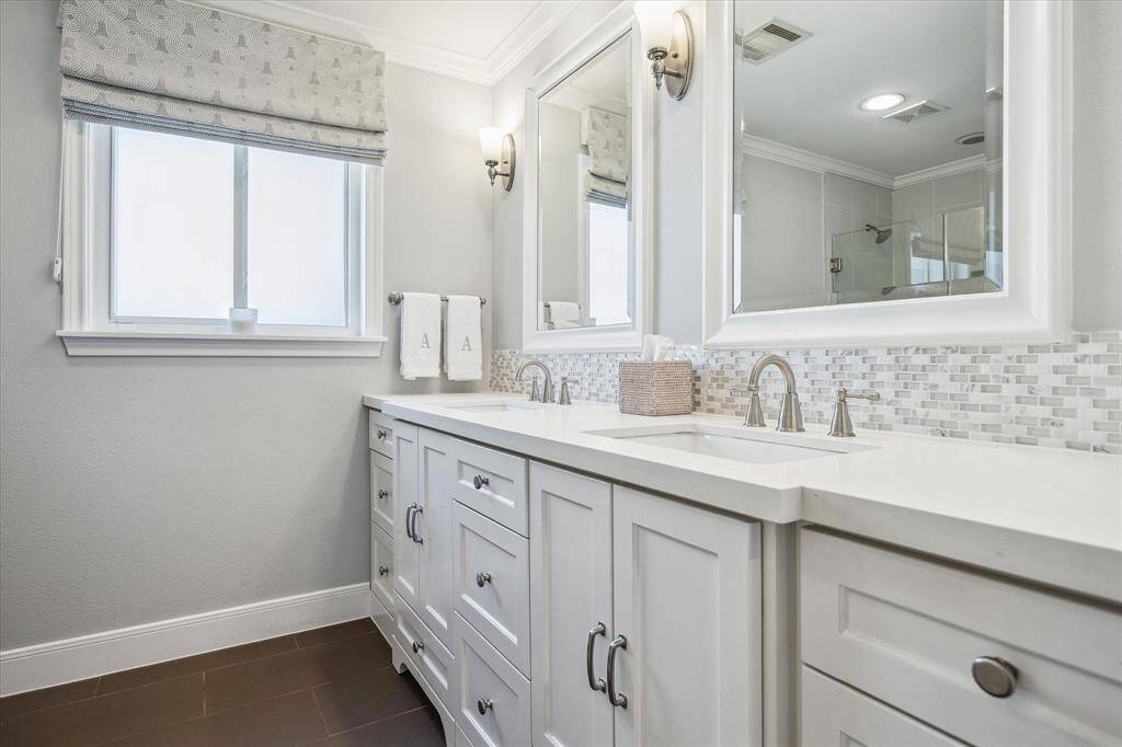 Experience convenience with a second main floor full bathroom featuring a walk-in shower and double sink vanity.