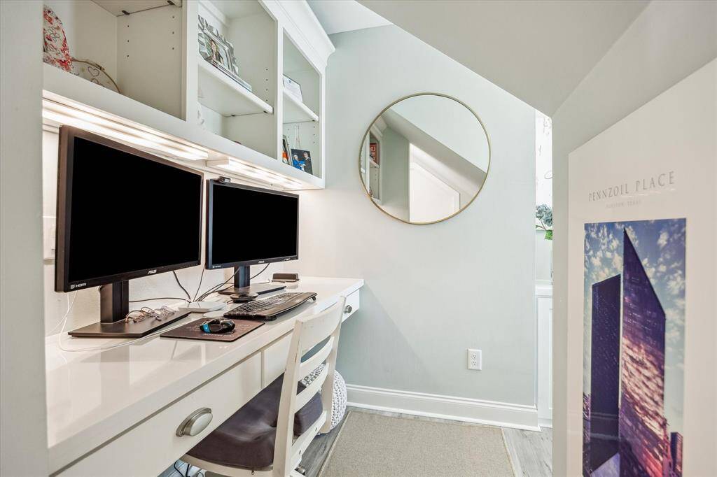 Charming nook off the upstairs game room, perfect as an office with built-in desk and shelves. Includes bonus air-conditioned storage, ideal for seasonal decor!