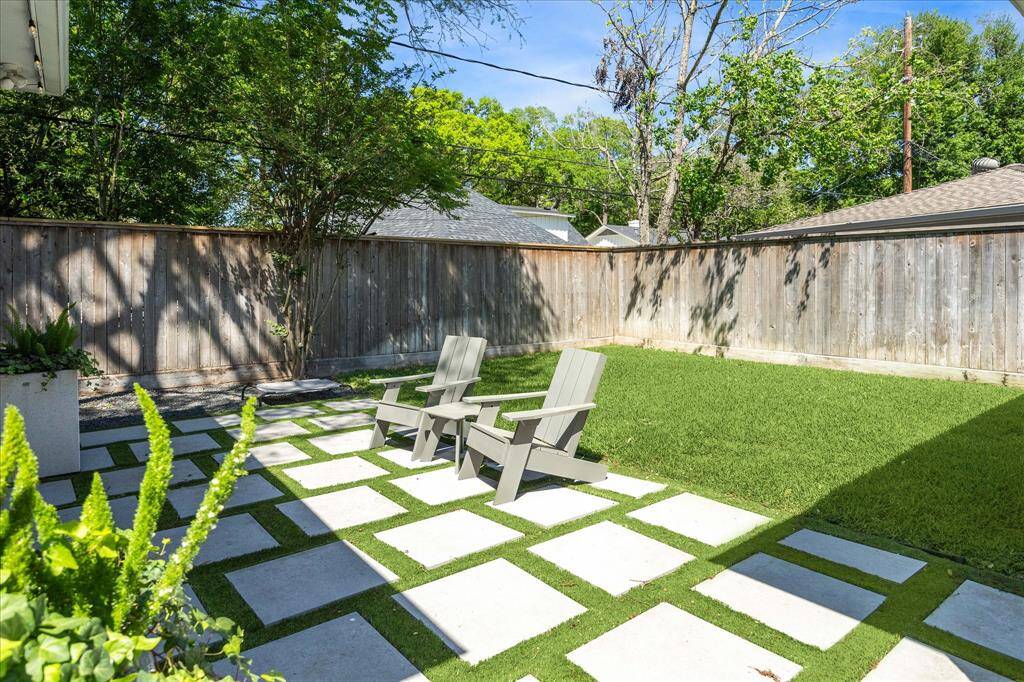 The backyard features artificial turf and pavers, with a real grassy patch for your furry friends to enjoy.