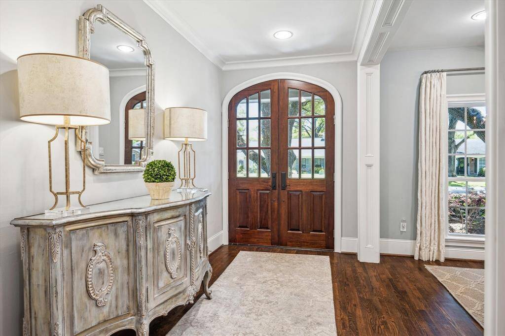 Step into the bright foyer through elegant arched double doors, featuring hardwood floors and exquisite millwork.