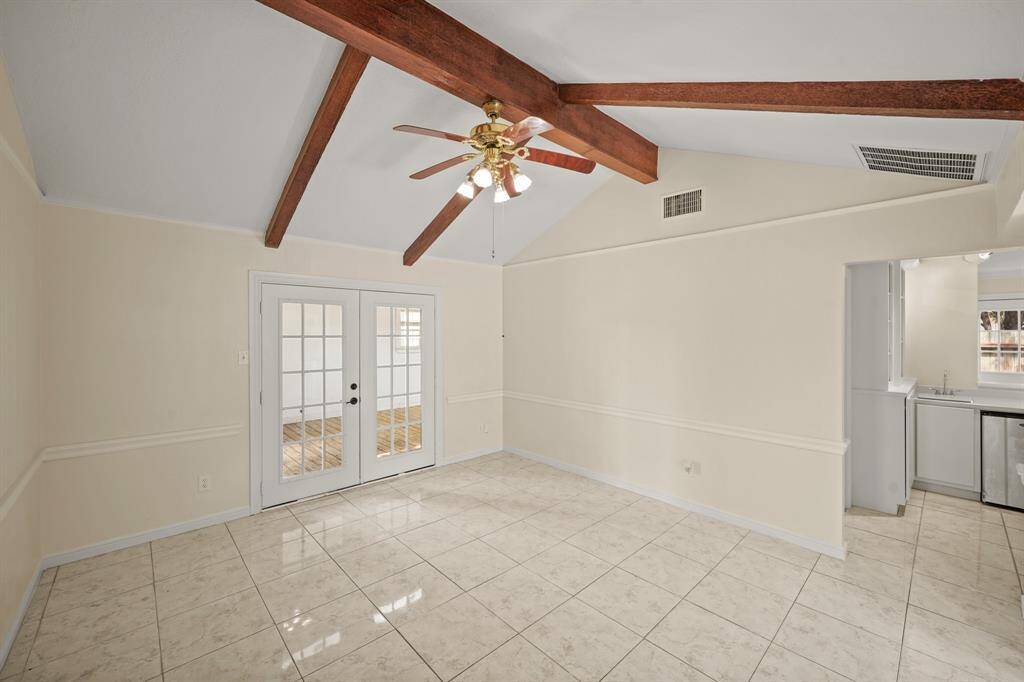 The den offers easy access to the covered deck, making it perfect for effortless indoor-outdoor entertaining.
