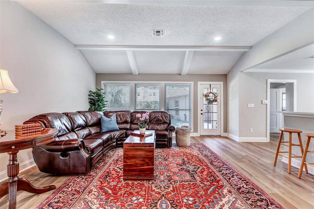 Expansive family room with soaring ceilings and elegant luxury vinyl plank flooring throughout.