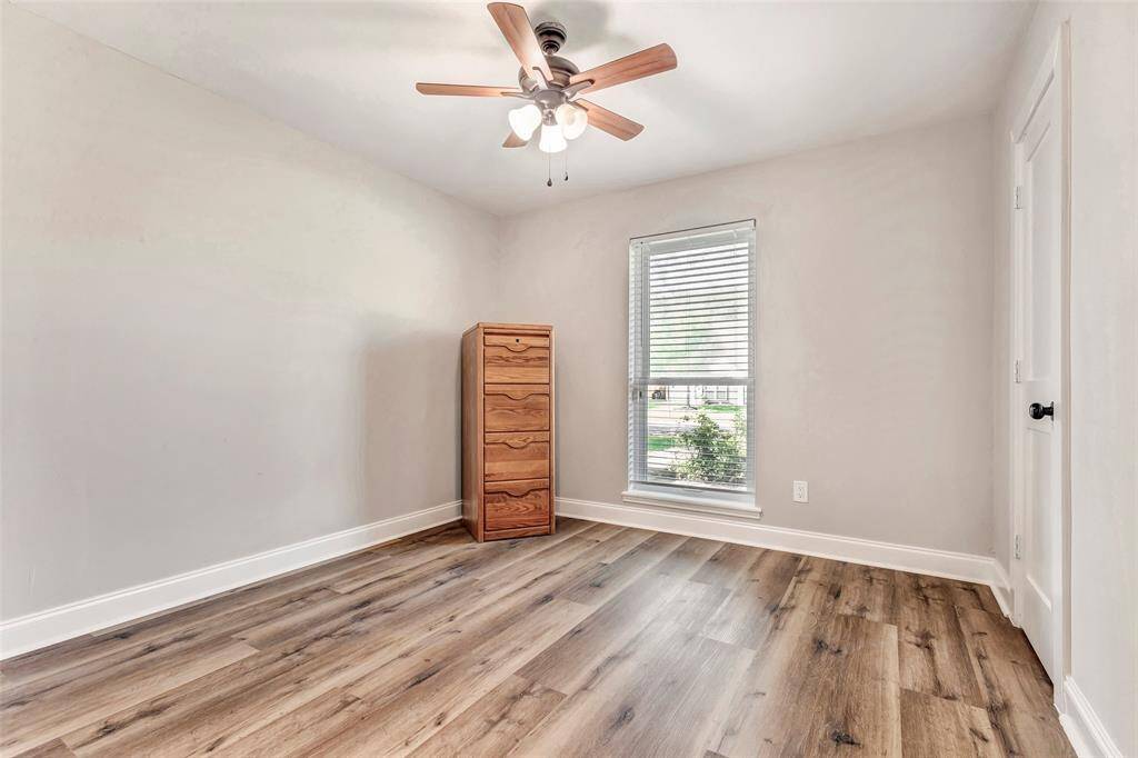 Cozy second bedroom with natural light, sleek hardwood floors, and a modern ceiling fan. Perfect for relaxation or another home office.
