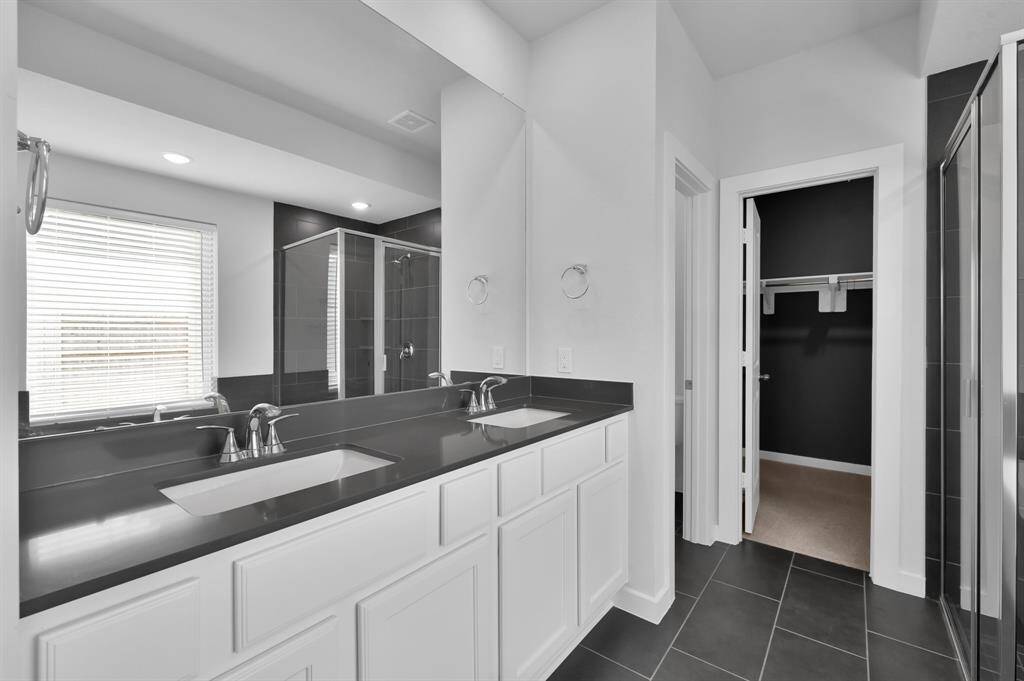 The primary en suite features dual vanities, granite countertops, and a spa-like feel