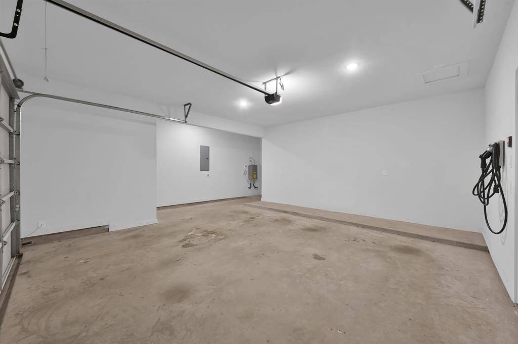 Oversized  garage with EV charging station and a 5-foot bump out of extra space.