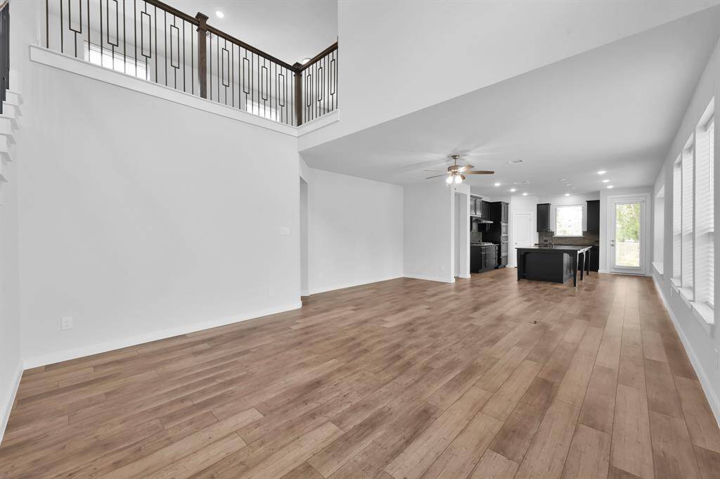 The open-concept living room, dining room, and kitchen is wrapped in windows and has warm luxury vinyl plank flooring. It is a perfect canvas for you to make it your dream entertaining, or hanging out place!