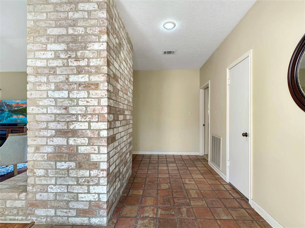 Extra wide foyer with brick wall welcomes you to this cozy home.