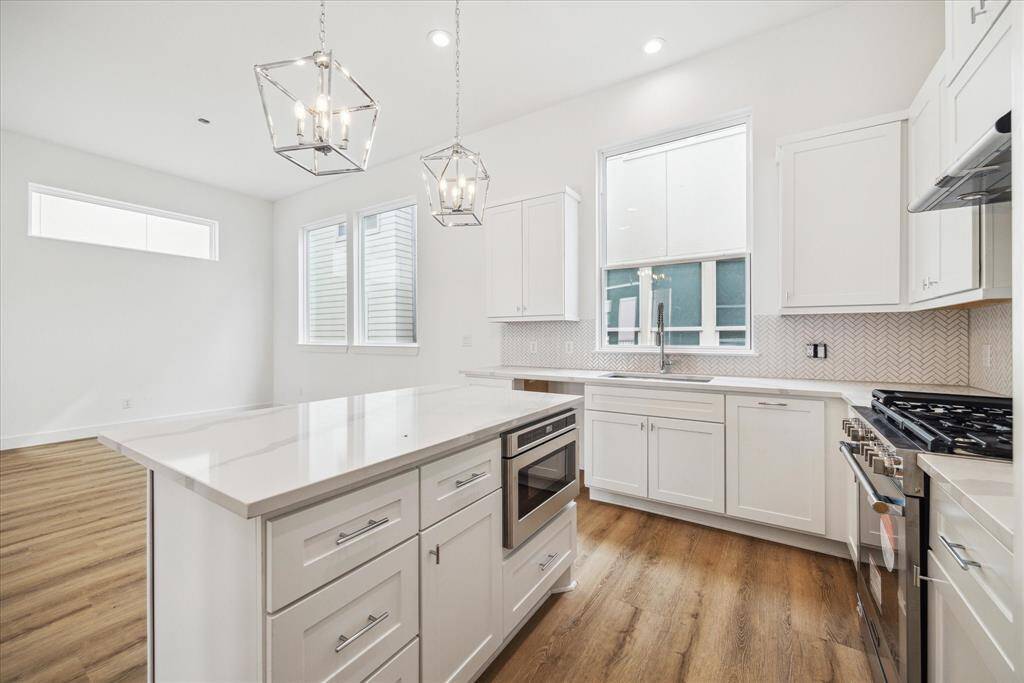 The kitchen has quartz countertops, farm house sink, upgraded shaker style, and soft close cabinets.