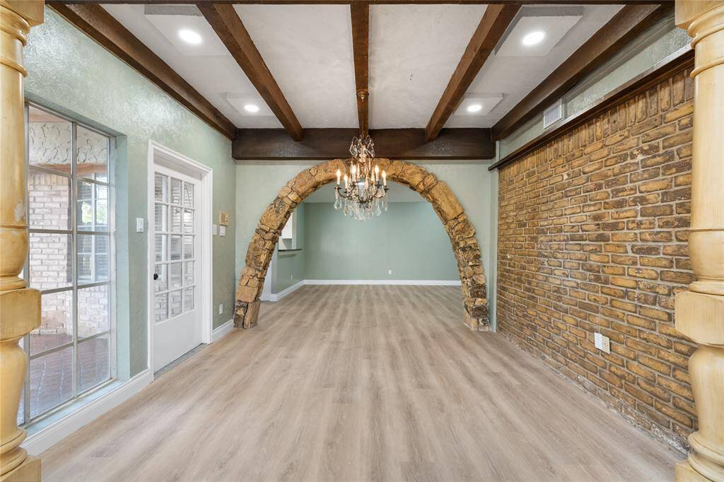 A look back at the dining area and the elegant stone arch. The open layout creates a seamless flow between the spaces, enhancing the home's inviting atmosphere. Great for entertaining.