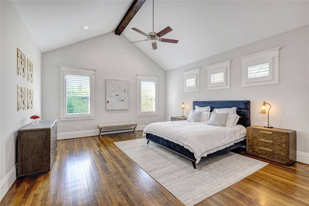 Spacious and serene primary suite featuring hardwood floors, abundant natural light, and beamed cathedral ceiling.