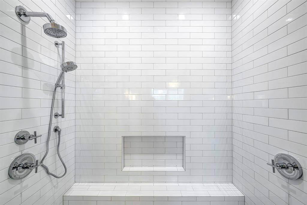 Primary bath has a walk-in shower with a large bench and recessed niche for convenient storage.