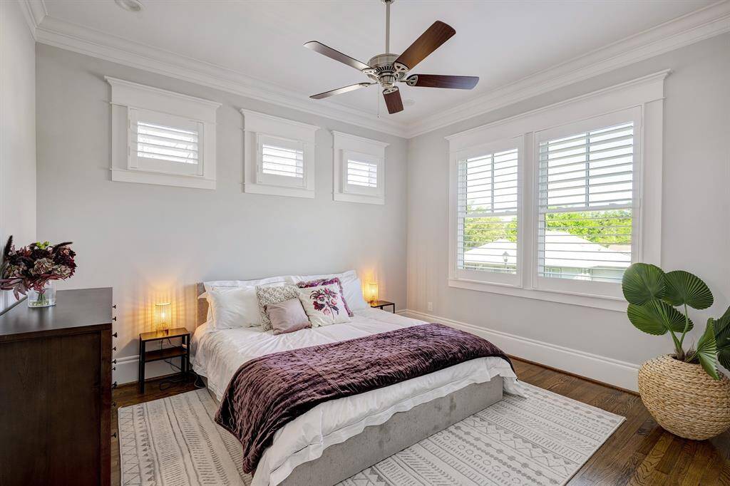 Inviting secondary bedroom with plenty of natural light, crown molding, and plantation shutters.