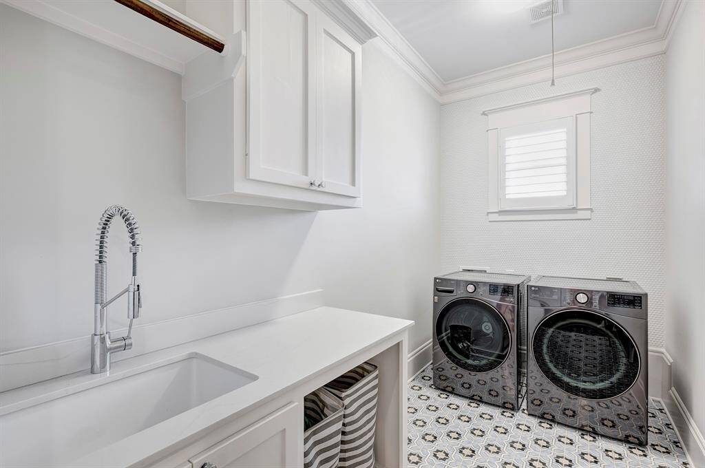 Laundry room with sink, hanging rod, and storage.