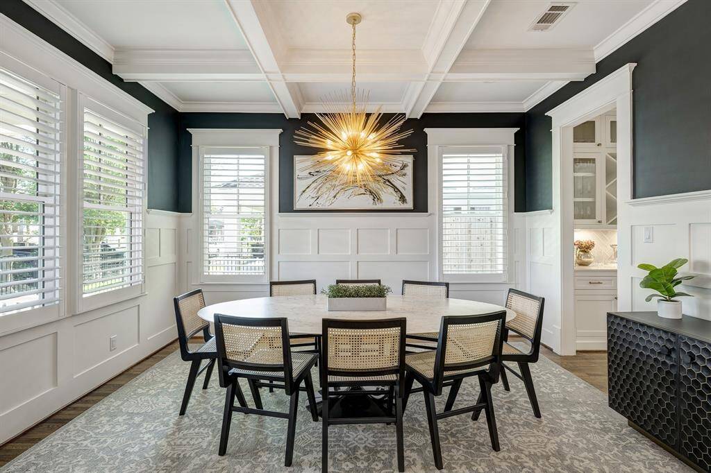 Bright and spacious dining room off the entry with coffered ceiling, timeless wainscoting, and access to the butler's pantry.